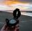 En hånd holder et kompass på en strand med havet i bakgrunnen