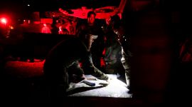 soldater som tydelig er i en operasjon av noe slag står rundt et kart og peker og diskuterer