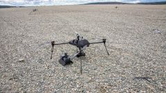 Drone med fire bein står på grusen