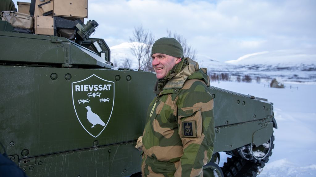 Hærsjef i uniform ved panservogn. Vinter, Snø. Blå himmel. Vidde.