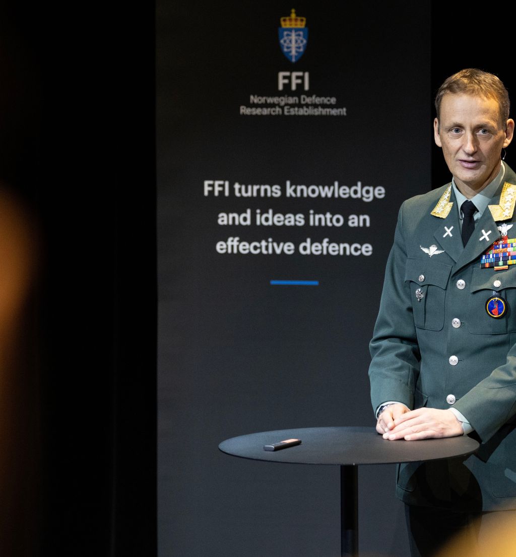 Forsvarssjef Eirik Kristoffersen i uniform står foran en sort FFI roll-up og snakker