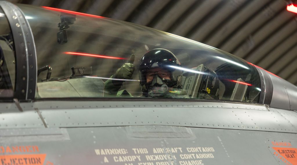 Forsvarsminister Bjørn Arild Gram gir tommel opp i cockpit på en F-16.