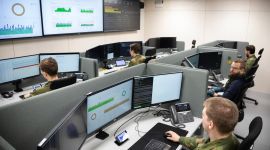 Bilde fra cyybersikkerhetssenteret på Jørstadmoen. Menn i uniform følger med på skjermer.