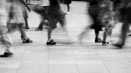 Føtter som går på en gate.  