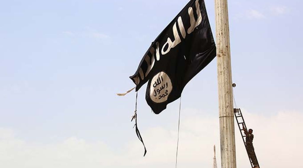 (FILES) In this file photo taken on April 30, 2017 A member of the US-backed Syrian Democratic Forces (SDF) removes an Islamic State group flag in the town of Tabqa, about 55 kilometres (35 miles) west of Raqa city as they advance in their battle for the group's de facto capital.The Islamic State jihadist group has executed one of dozens of Druze hostages abducted from Syria's southern province of Sweida last month, a Syrian news outlet and a monitor said on August 5. IS killed the 19-year-old male student on August 2 after kidnapping more than 30 people, mostly women and children, from a village in Sweida during a deadly rampage on July 25, the head of the Sweida24 news website Nour Radwan said. / AFP PHOTO / DELIL SOULEIMAN