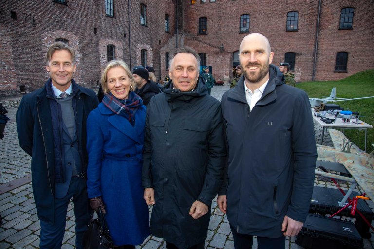 Fire personer oppstilt foran Fanehallen på Akershus festning.