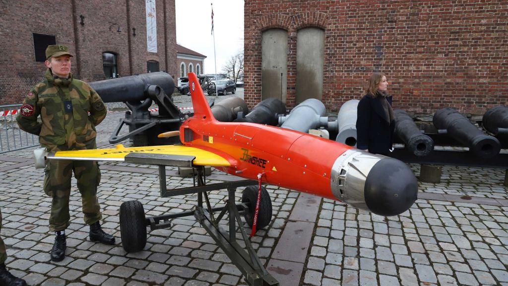 En rød Banshee-drone. En soldat står bak drona.