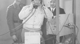 Fra utviklingen av et telesamband. Tre forskere bak en radio.