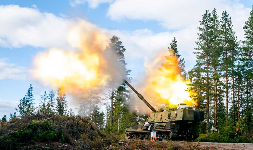 En K9 Vidar prøveskyter. Røyk og ild over og på siden av det selvdrevne artilleriet.
