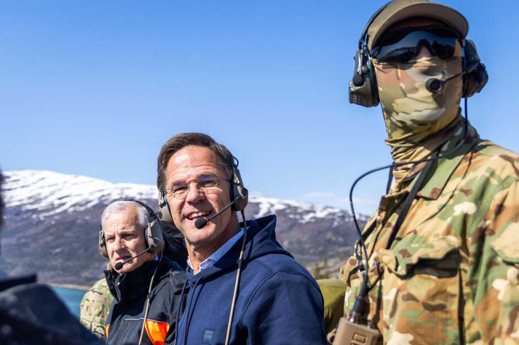 Jonas Gahr Støre, Mark Rutte og en soldat. Alle har headset på.