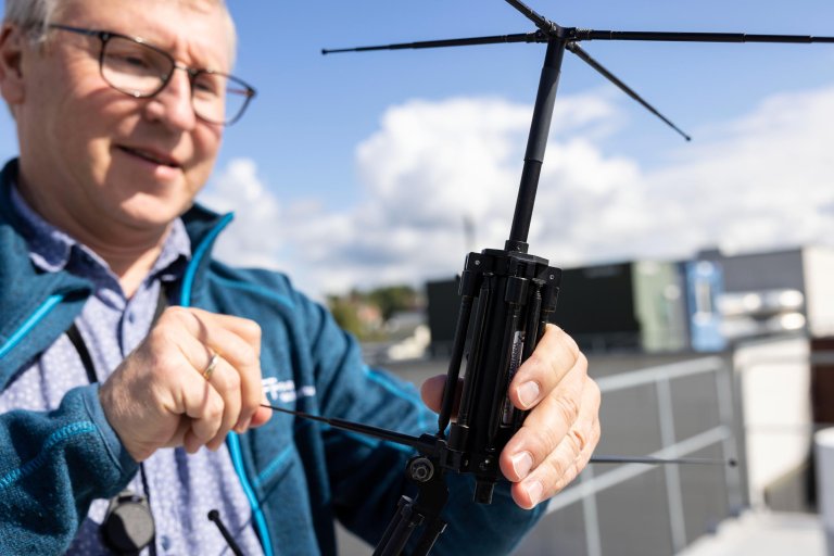 Lars Erling Bråten med en antenne på taket av FFI på Kjeller.