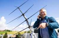 Lars Erling Bråten på taket av FFI på Kjeller med en antenne.