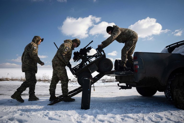 Tre ukrainske soldater laster en UGV ut av en pickup.