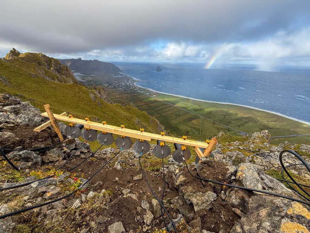 antenne montert med treplanker i fjellsidekabler, skyer, utsikt over havet