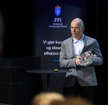 Bendik Sagsveen viser frem en 3D-printet del til et kjøretøy.