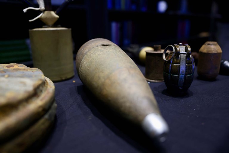 Gamle miner og granater som ligger på et bord.