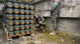 To menn registrerer ammunisjon stablet på en pall.