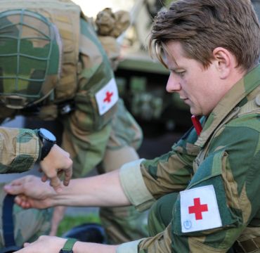 Soldater fra Forsvarets sanitet sitter på huk