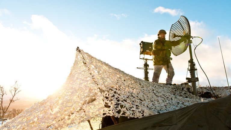 Soldat i sambandsbataljonen justerer antenne.