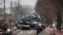 People look at the gutted remains of Russian military vehicles on a road in the town of Bucha, close to the capital Kyiv, Ukraine, Tuesday, March 1, 2022