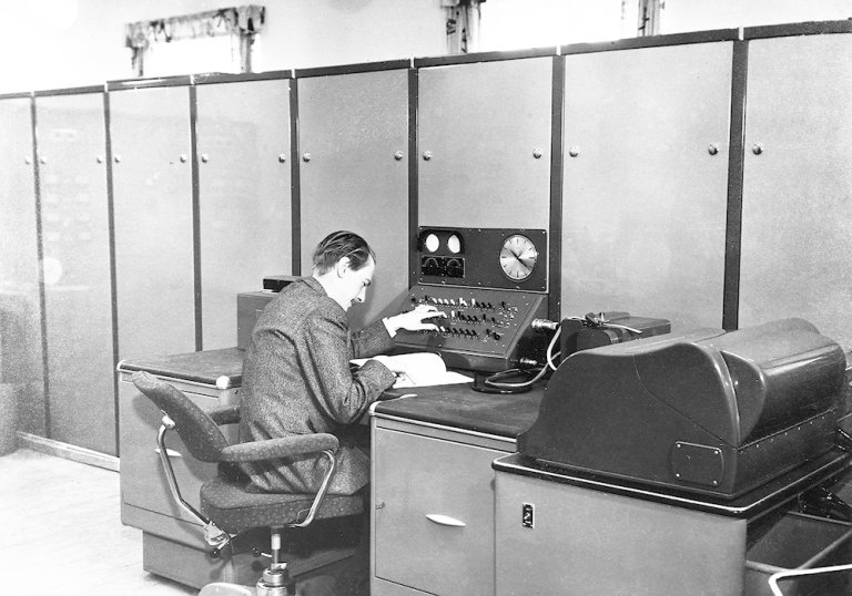 Harald Keilhau sitter ved FFIs første digitale datamaskin med 2000 vakuumrør og 20 kW varmetap. Ferranti Rapid Electronic Defence Research Institute Computer (FREDRIC) representerte et gjennombrudd i hvordan forskerne løste kompliserte matematiske problemer. 