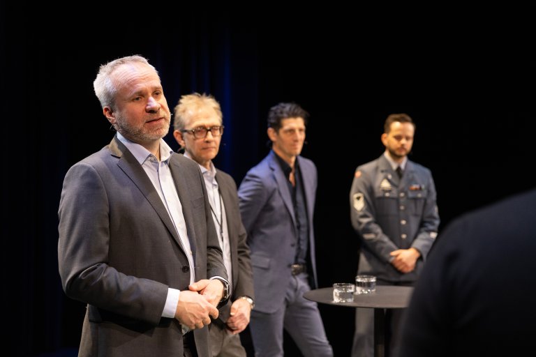 Fire menn på scenen i Deichmansalen. I forgrunnen Espen Lippert.