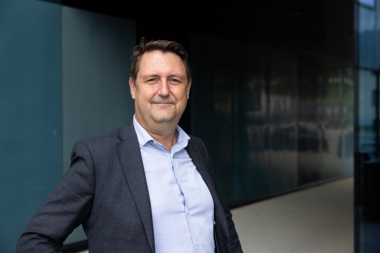 Portrett av forsker i dress. Tatt utendørs.