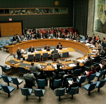 Oversiktsbilde av møtelokale med bord i midten og stoler i sirkler rundt