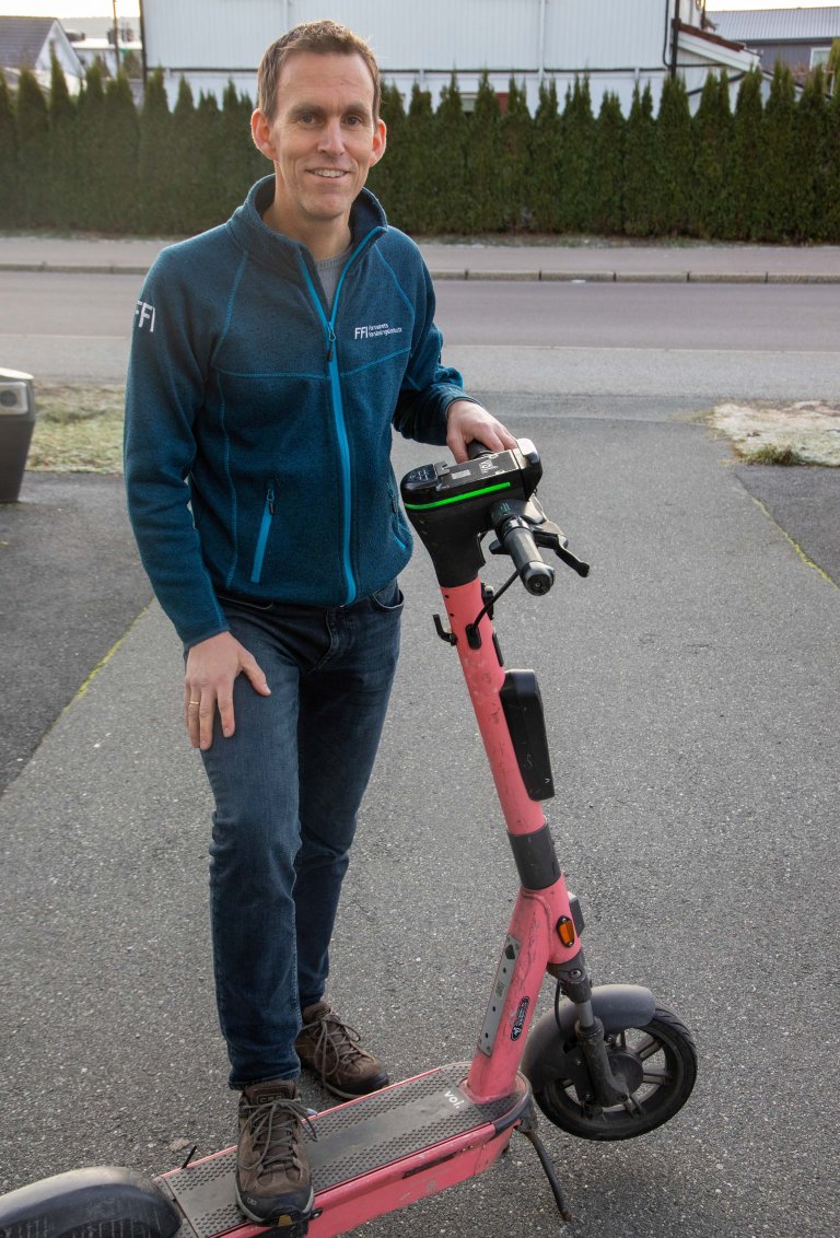 Helge Weydahl på en sparkesykkel utenfor FFI.