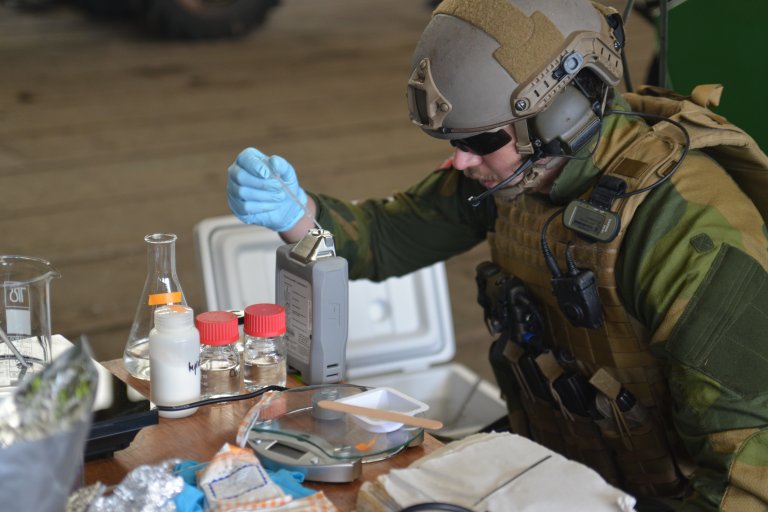 Fullt utstyrt soldat foran bord med ingredienser til hjemmelagde ekspolosiver