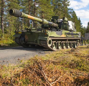 K9 Vidar artilleri på en grusvei i et skogsområde.
