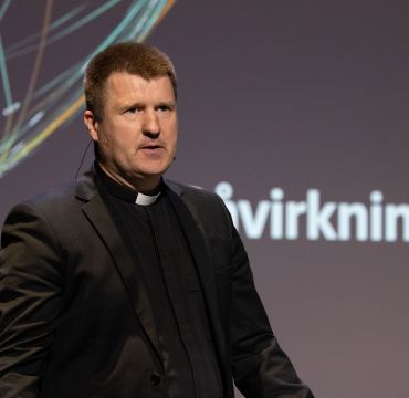 Øystein Mathisen, med svart dress, på scenen under Påvirkningskonferansen 2025.