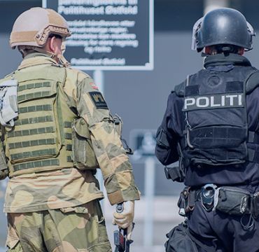Politi og soldat samarbeider i samfunnsikkerhetsøvelse.