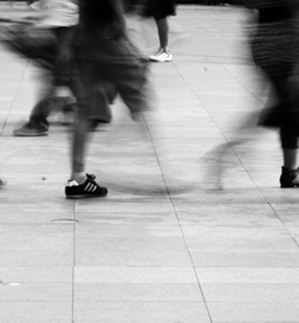 Føtter som går på en gate.  