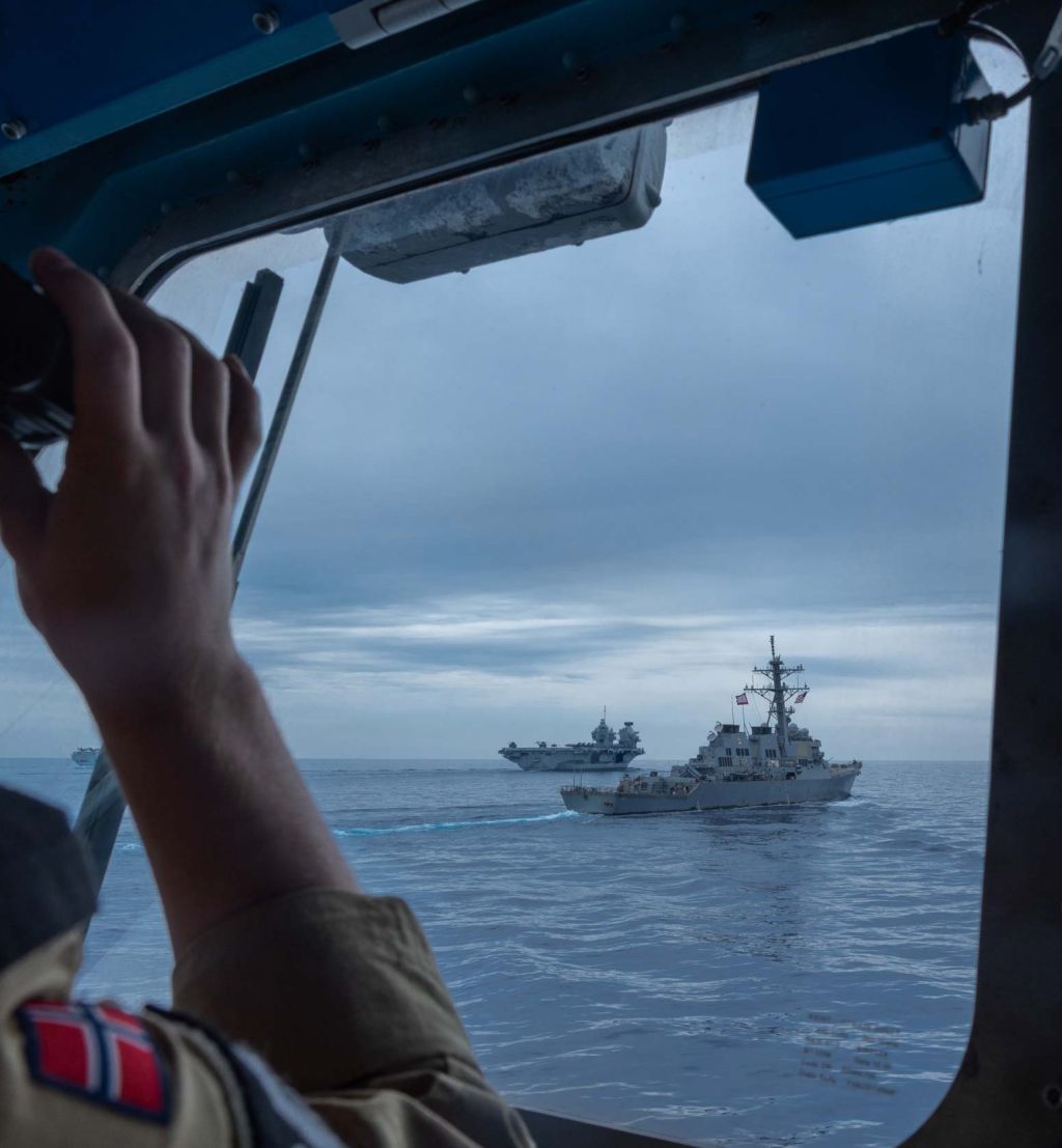 En soldat bruker kikkerten og ser to marinefartøy foran seg.