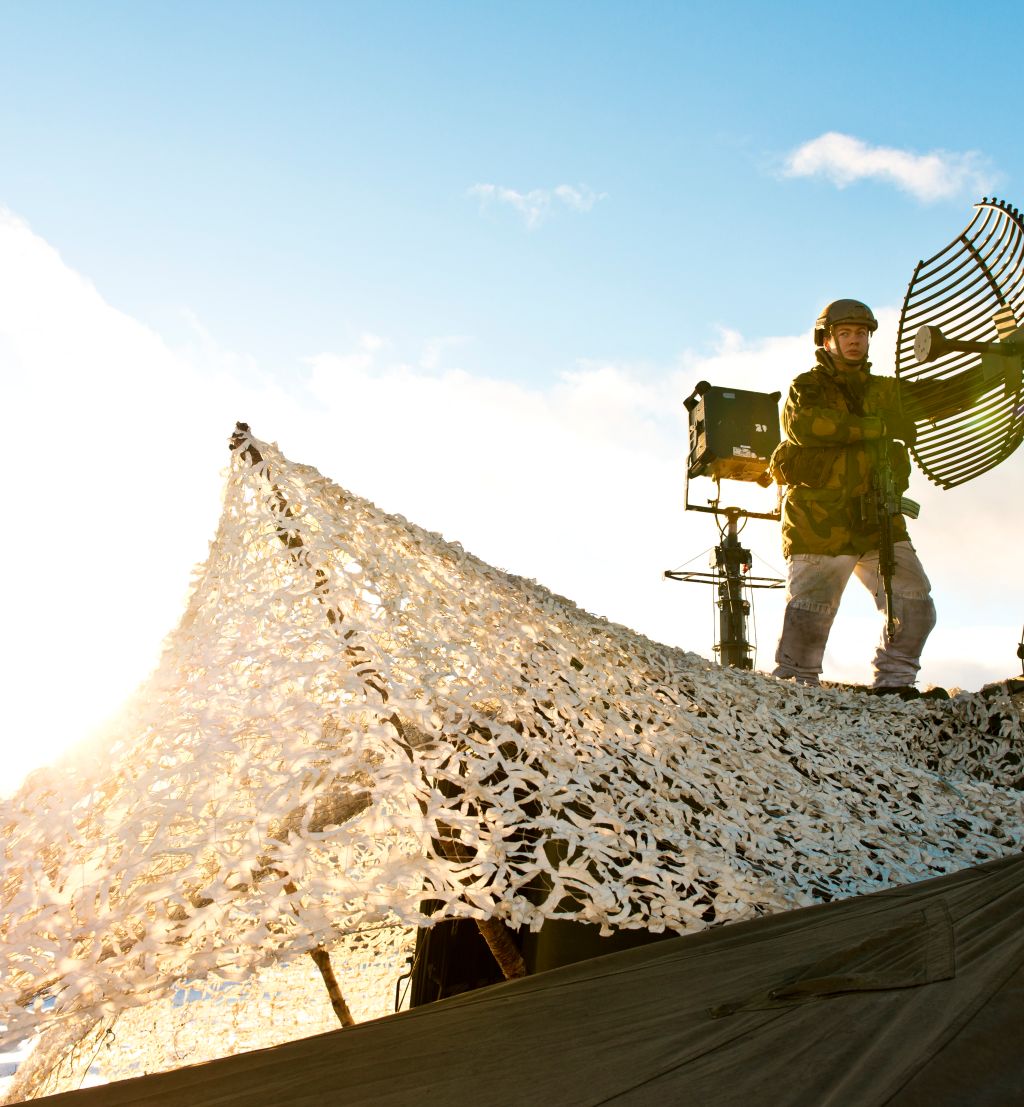 På grunn av kraftig vind, må antennene til knutepunktslaget i Sambandsbataljonen justeres jevnlig. /Soldiers from Signal Battalion adjust an UHF-antenna.