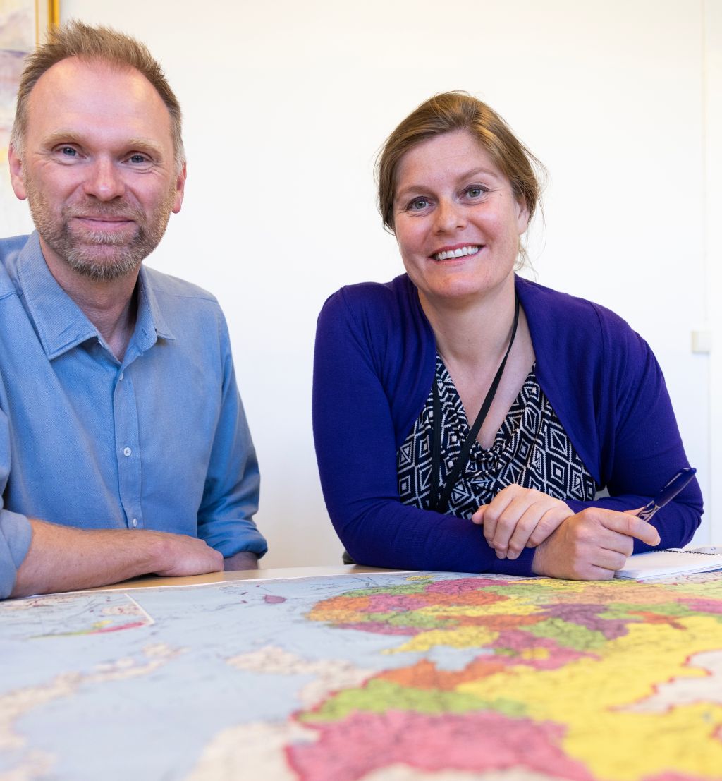to FFI-forskere sitter bak et bord med et kart over Kina foran seg