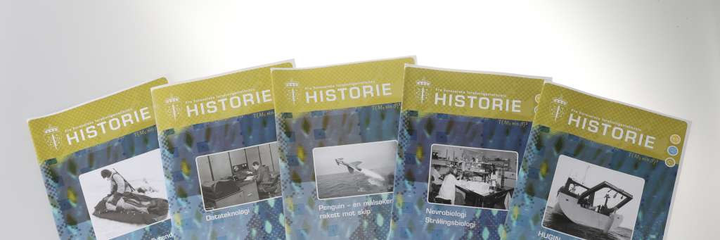 5 historiehefter ligger i vifteform på et bord. Foto