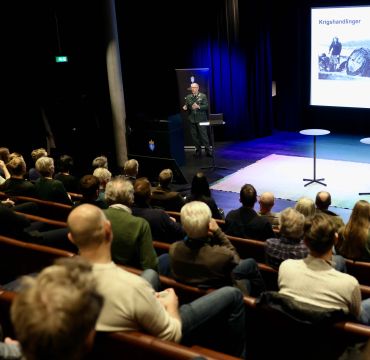 Oversiktsbilde fra Deicmansalen. Fotografen står bak publikum og fotograferer Geir P. Novik og hans persentasjon.
