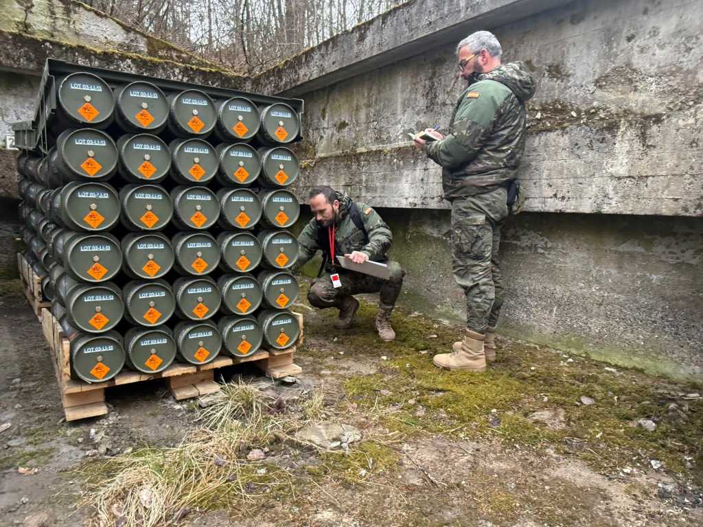 To menn registrerer ammunisjon stablet på en pall.