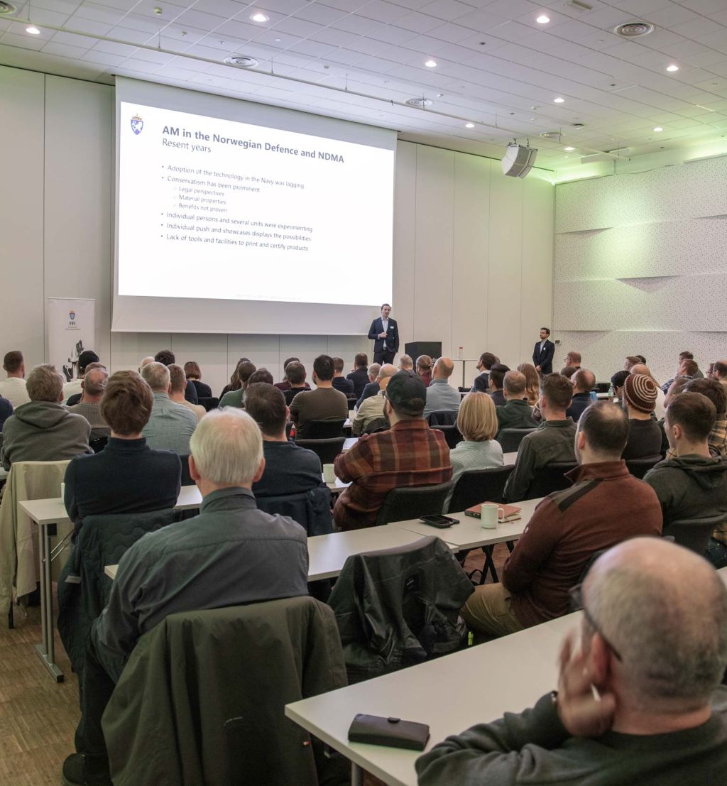 Publikum følger med på en presentasjon på storskjem.