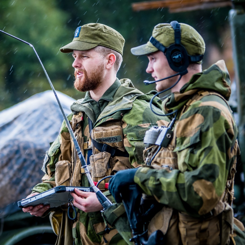 To militærkledde menn med samband på øret og nettbrett i hånda